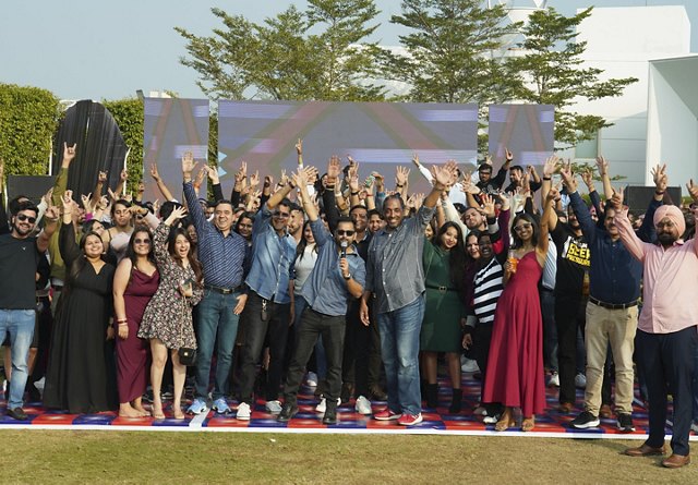 Group of employees from Greystar's India office raising their hands.