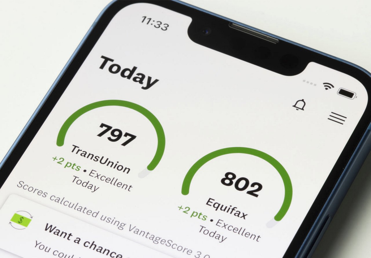 A close-up photo of a smartphone displaying credit score information on the screen, showing detailed data and wording to help the user better understand their score.