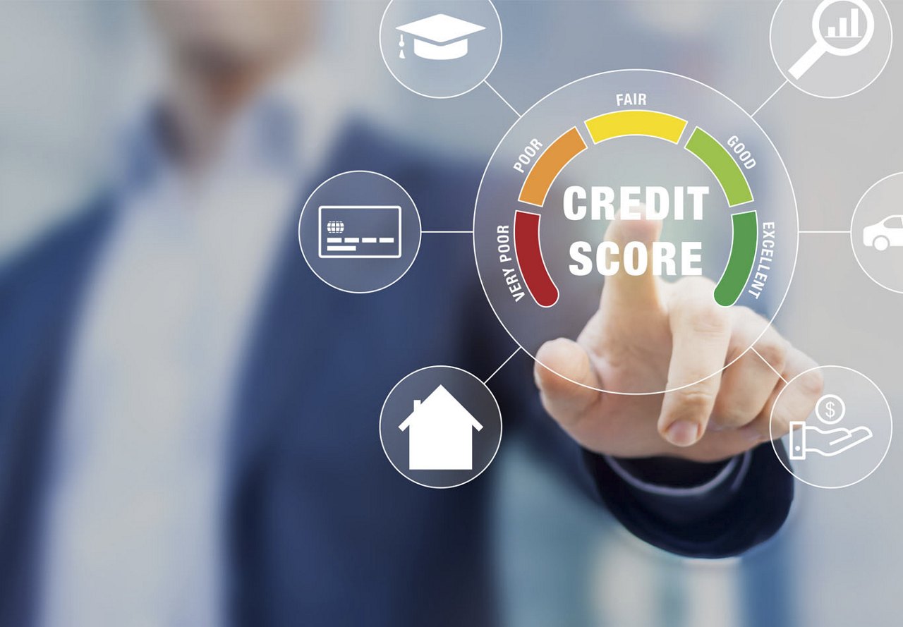 A person pointing at a graphic in the foreground showing a breakdown of the factors contributing to a credit score, with a blurred background behind them.