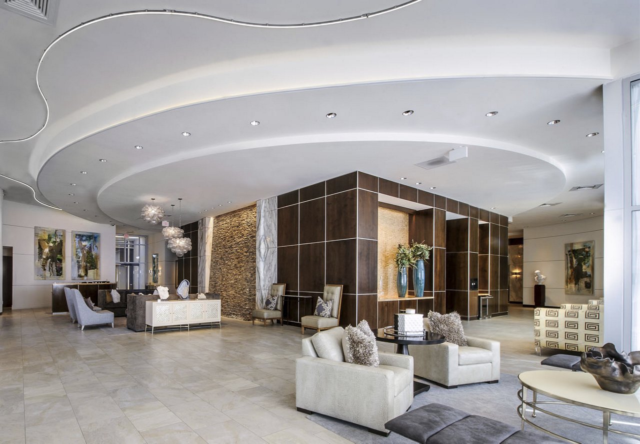 A modern lobby in a Houston apartment community featuring neutral furniture, stylish light fixtures, and sleek tile flooring for a contemporary, welcoming atmosphere.