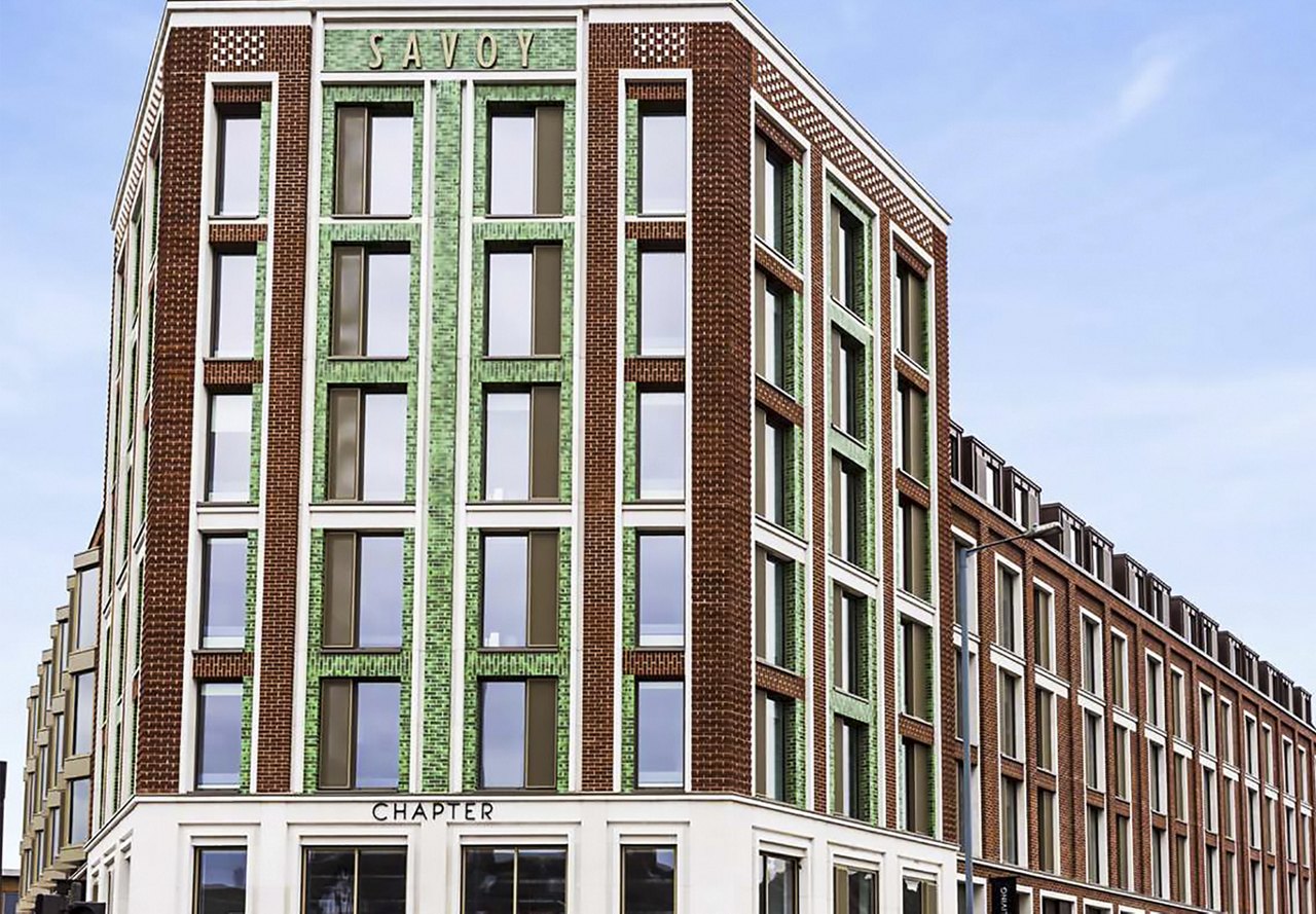 Exterior view of The Savoy building in the UK, transformed into student housing by Greystar, with a clear blue sky in the background.