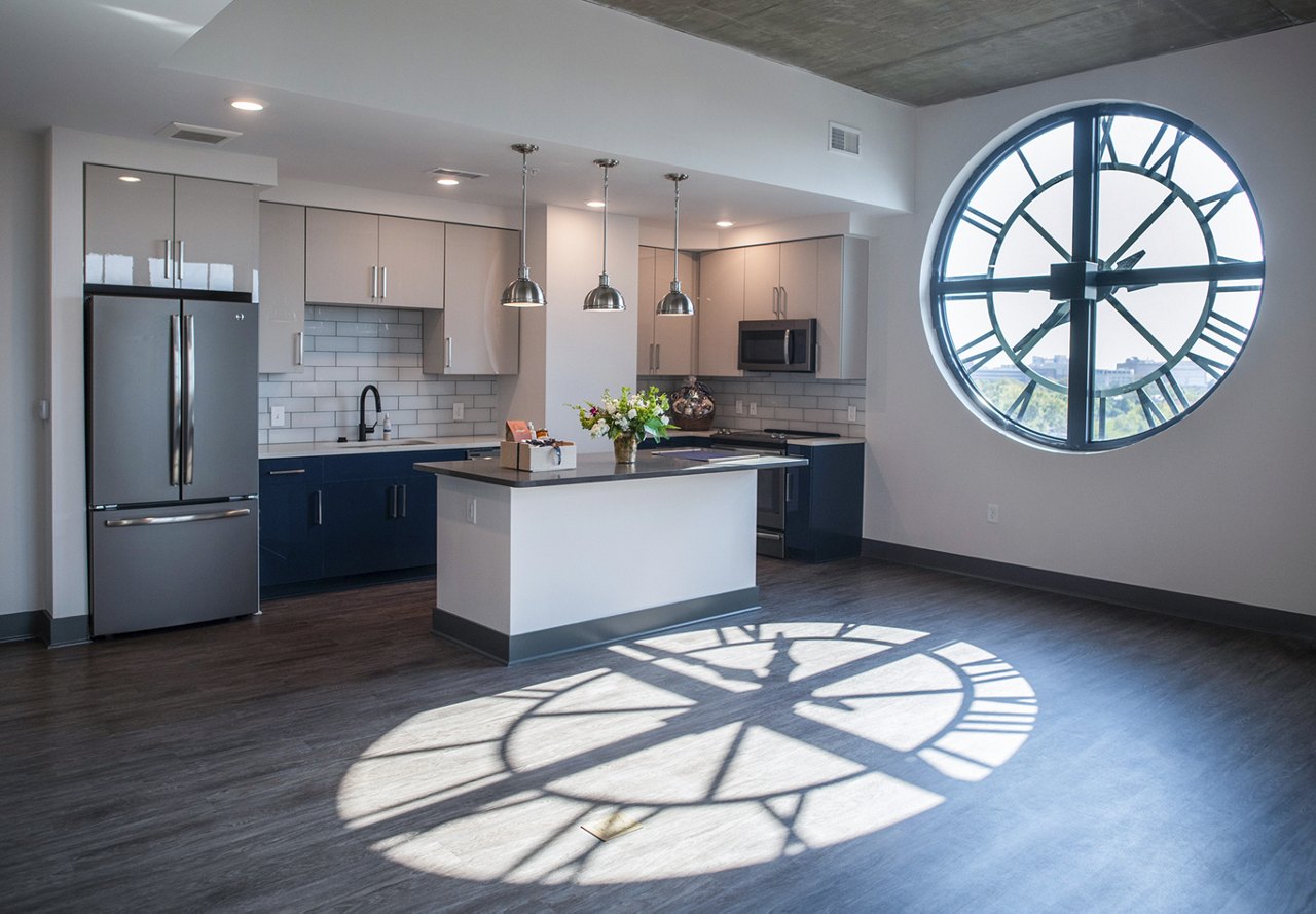 A view of the penthouse apartment at The Guild in Charleston, featuring a unique clock window that looks into the living space.