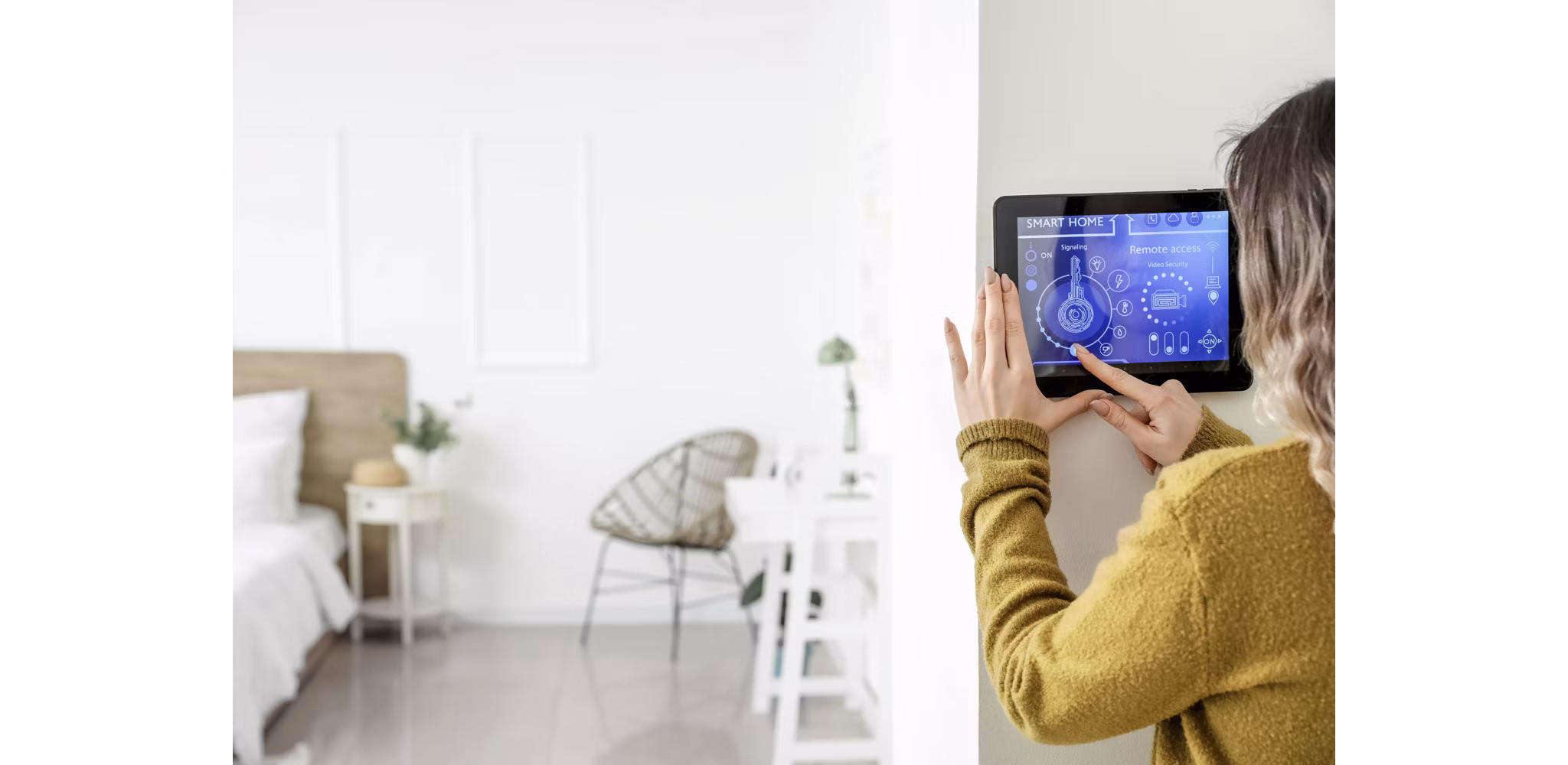 Woman using a digital panel in her home to adjust the smart thermostat, with a softly blurred view of her bedroom in the background.