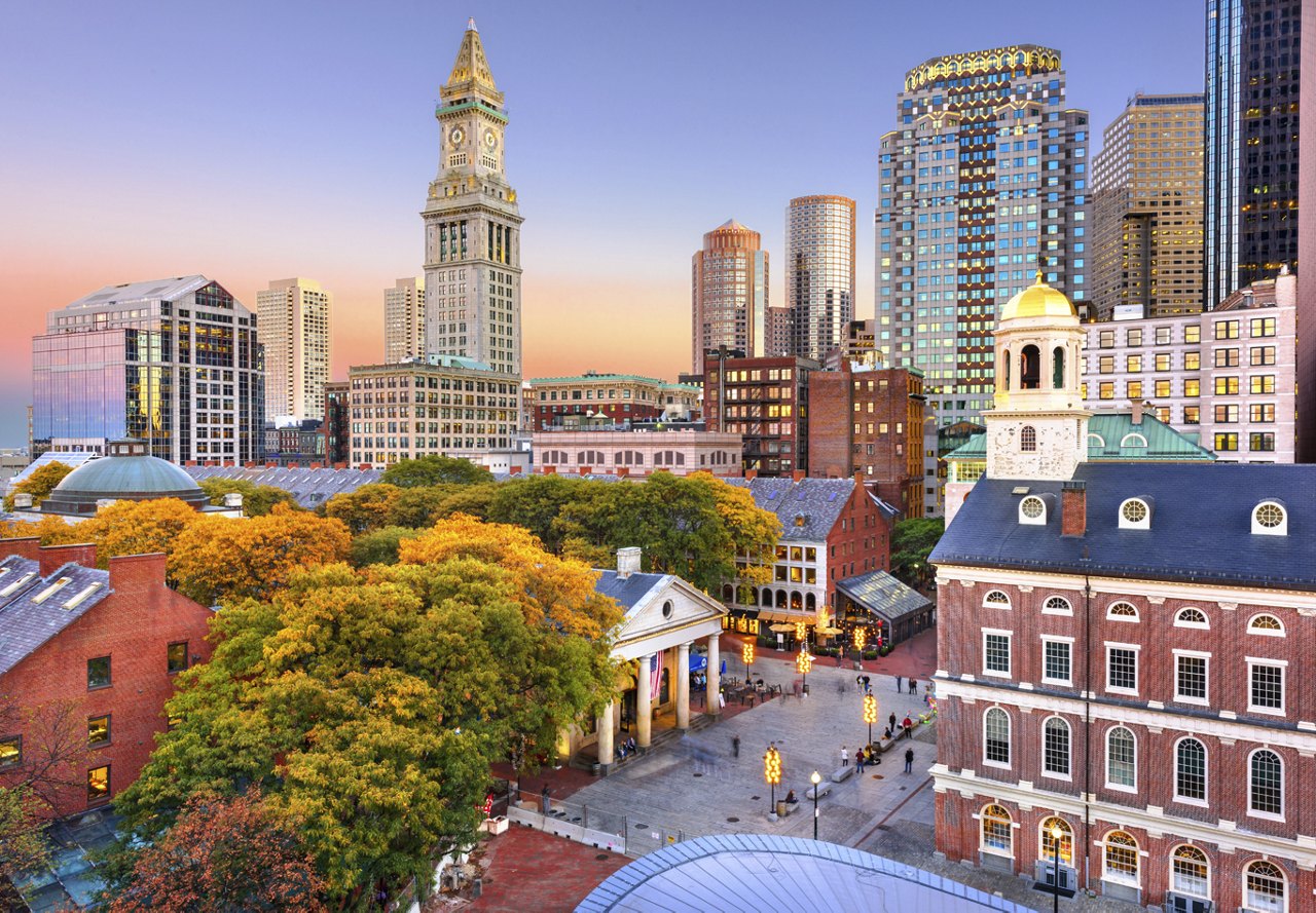 An image of Boston showcasing its unique buildings and vibrant colors, with an ombre sky in the background, highlighting the excitement of the city and the beauty of its architecture.