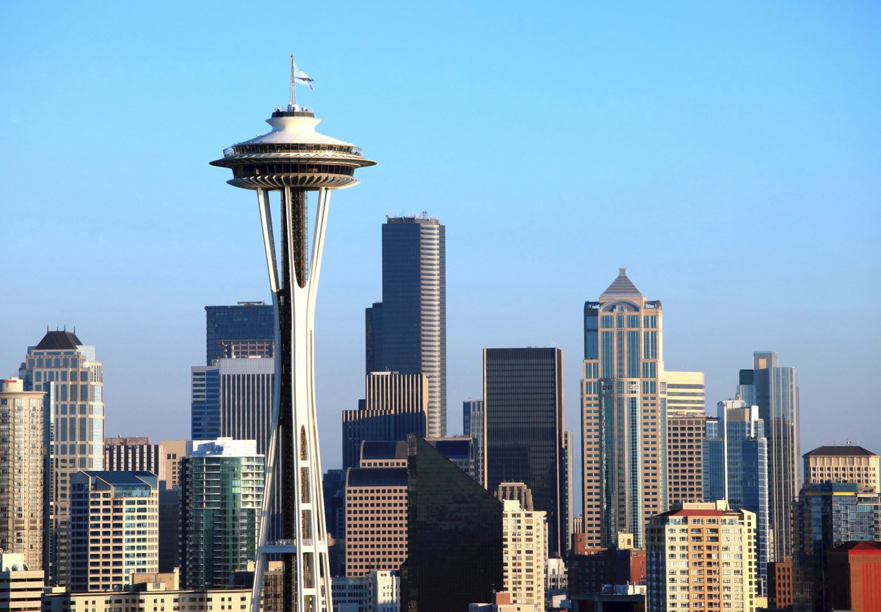 A view of Seattle, Washington, featuring the city's diverse buildings against a clear blue sky, showcasing the urban landscape.