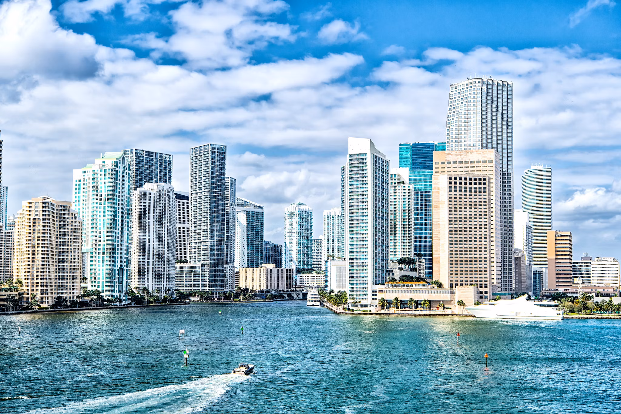 miami skyline. Yachts sail on sea or ocean water to city skyscrapers on cloudy blue sky in Miami, USA. Summer vacation, wanderlust, travelling, lifestyle concept.