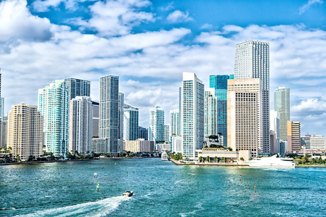 miami skyline. Yachts sail on sea or ocean water to city skyscrapers on cloudy blue sky in Miami, USA. Summer vacation, wanderlust, travelling, lifestyle concept.