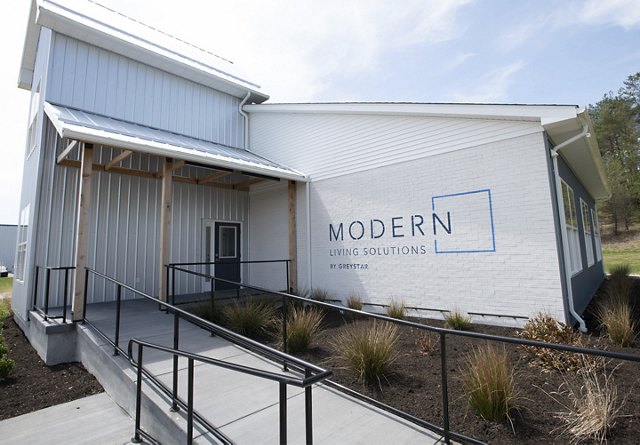 Modern industrial-style building with white walls and 'MODERN Living Solutions' branding.