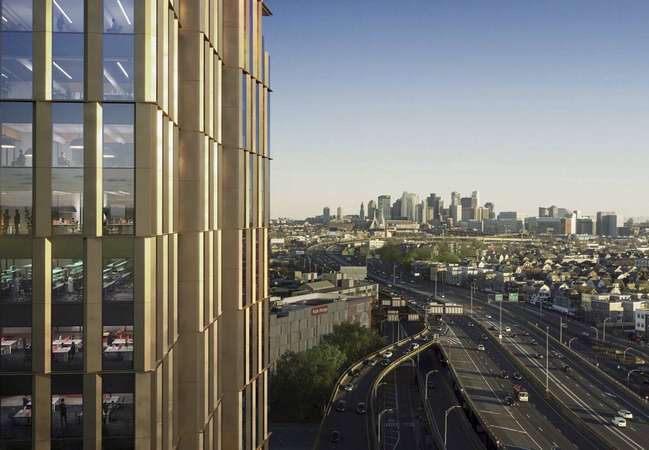City skyline viewed from a high-rise building with reflective glass windows, overlooking a busy highway.