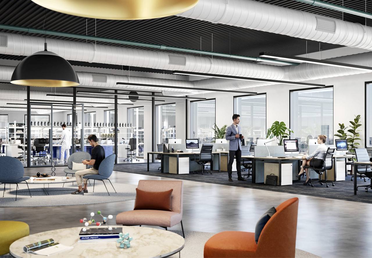Modern office space with employees working at their desks and informal seating areas.