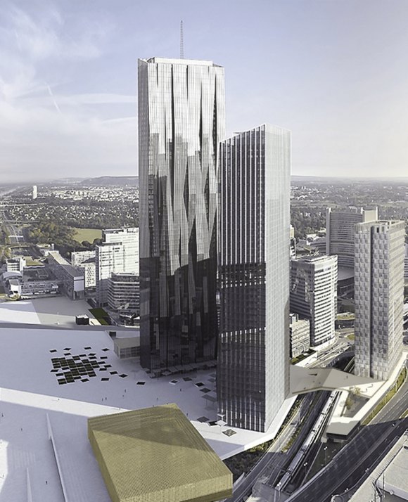 A pair of reflective glass skyscrapers towering over a cityscape, with a large public square and green-roofed buildings, set against a clear sky.