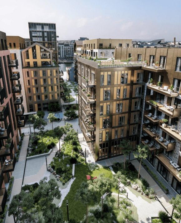 A modern residential area with a landscaped communal garden, featuring a variety of contemporary apartment buildings and a canal in the distance.