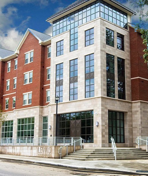 Brick and stone facade of the Lewis Academic Building with large windows and a glass atrium.