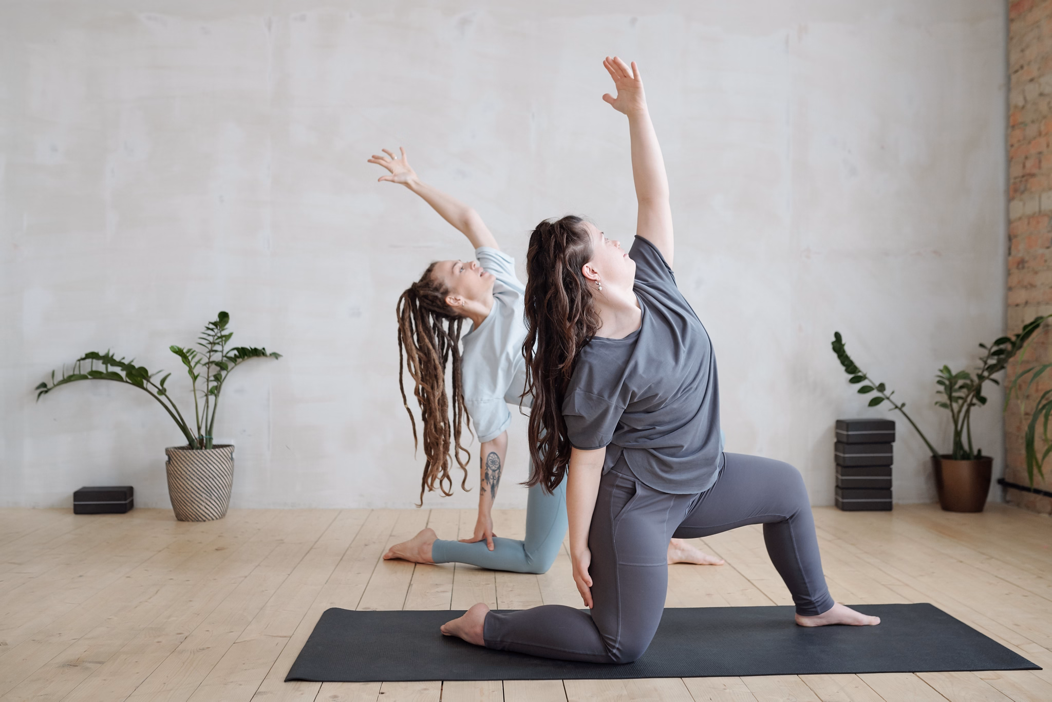 Small group of young females in activewear doing yoga exercise on mats