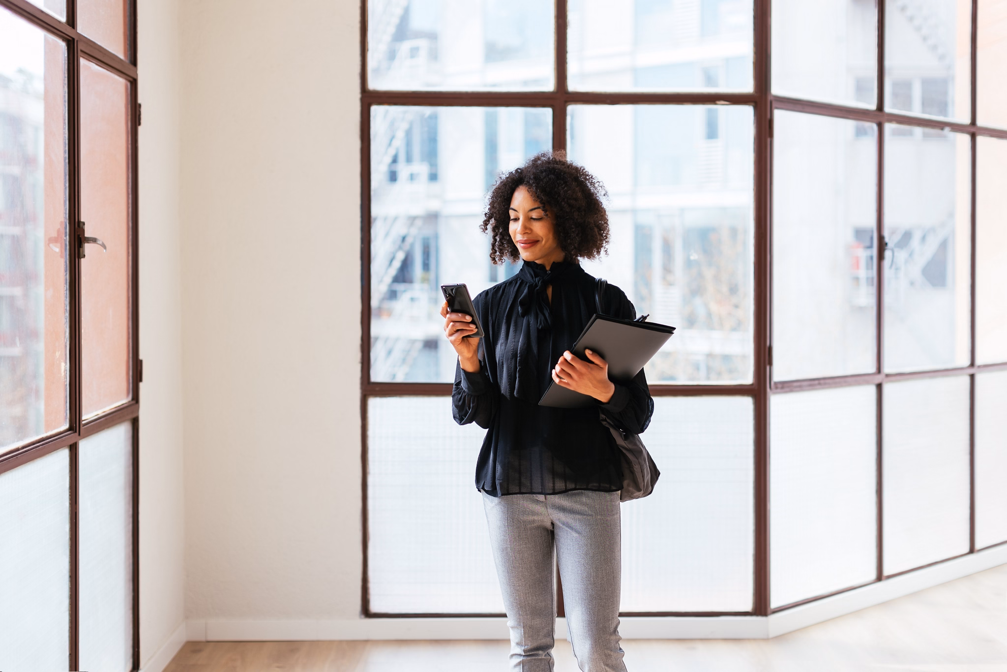 Positive black realtor using smartphone