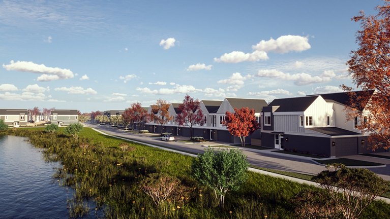 Suburban neighborhood with modern single-family homes along a tree-lined street next to a calm lake.