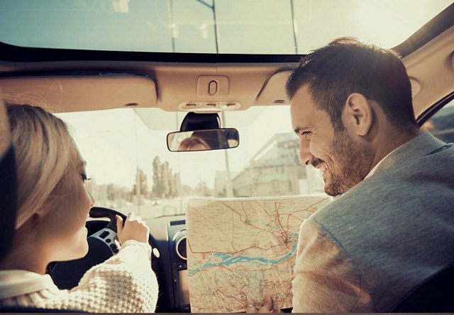 couple holding map in car for roadtrip | Blog | Greystar