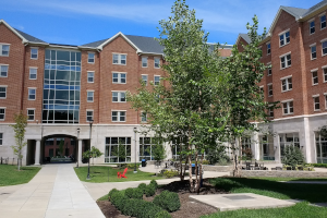 Exterior view of Haggin Hall, a modern dormitory building at the University of Kentucky, showcasing its brick facade and large windows under a clear sky.