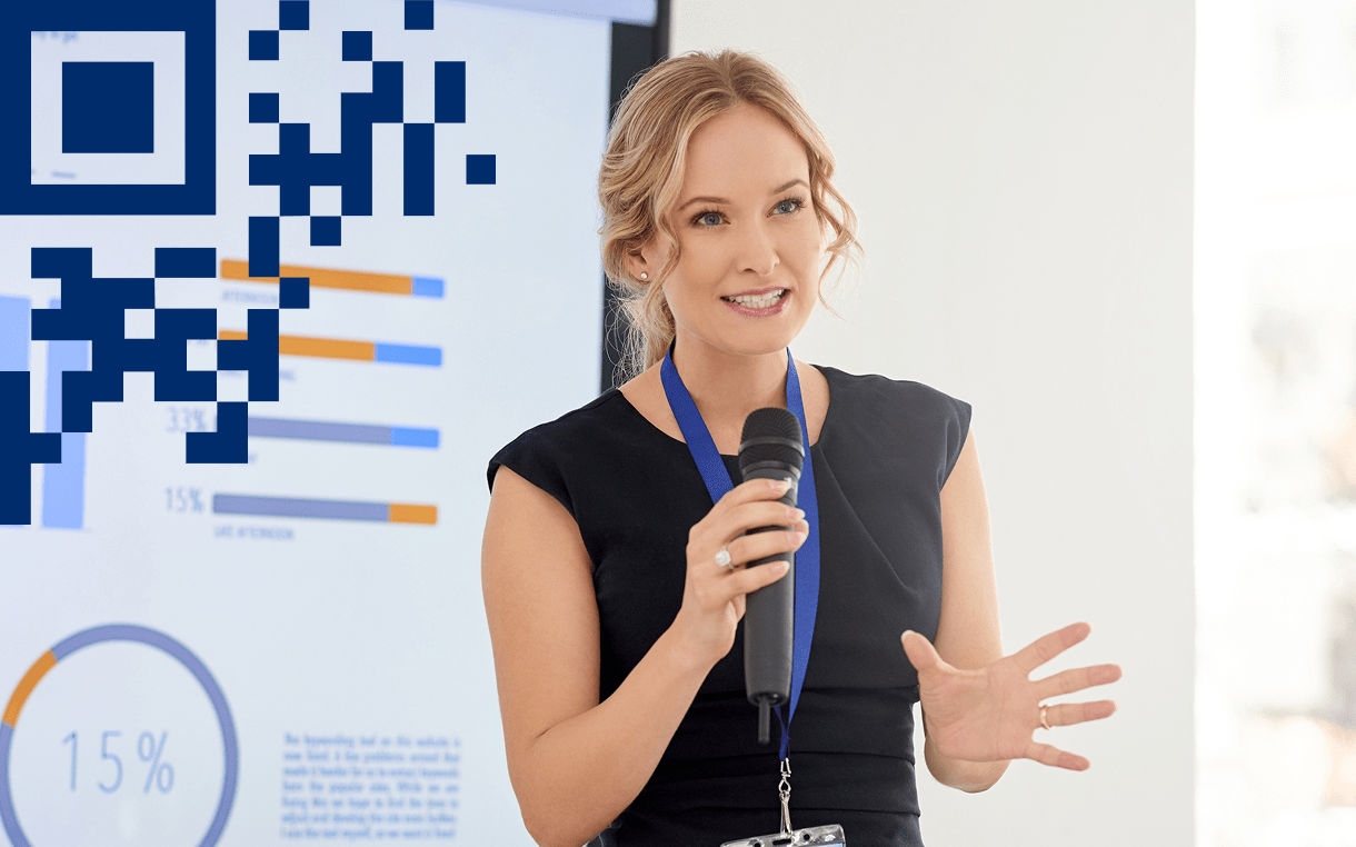Conference speaker giving presentation with a microphone in hand, 2D carrier in left corner