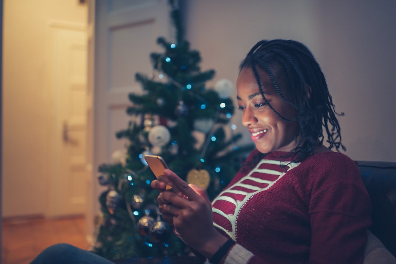 African American woman online Christmas shopping at home