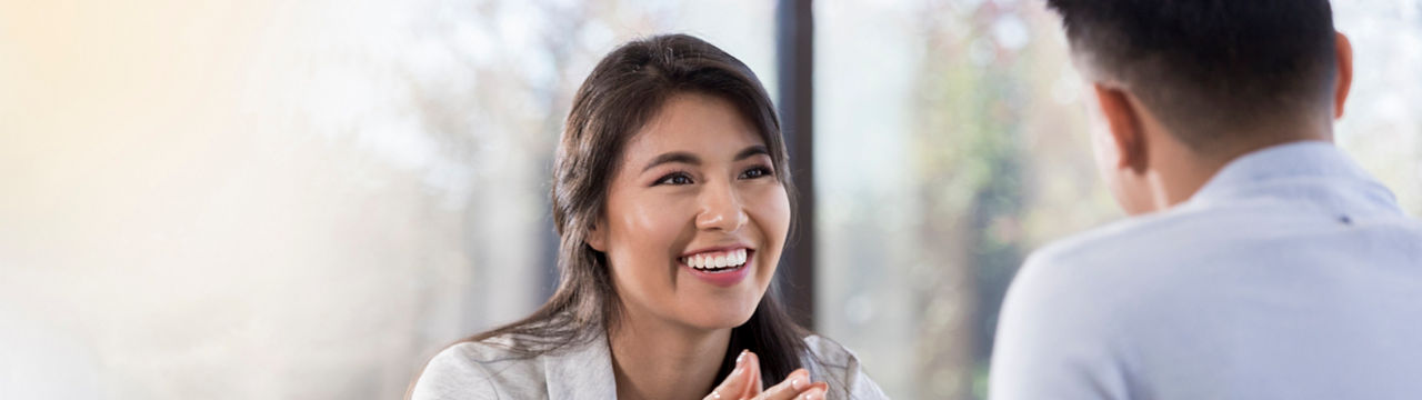 Smiling young Hispanic businesswoman meets with a male colleague