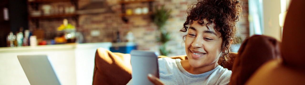 Close up of a young woman using a phone at home