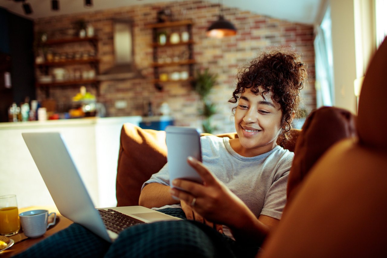 Close up of a young woman using a phone at home