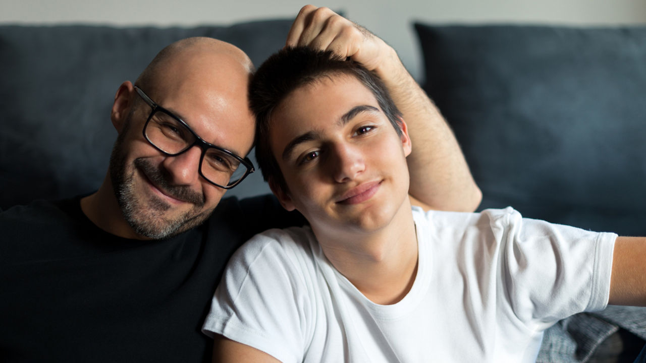Portrait of father and son bonding in a living room.