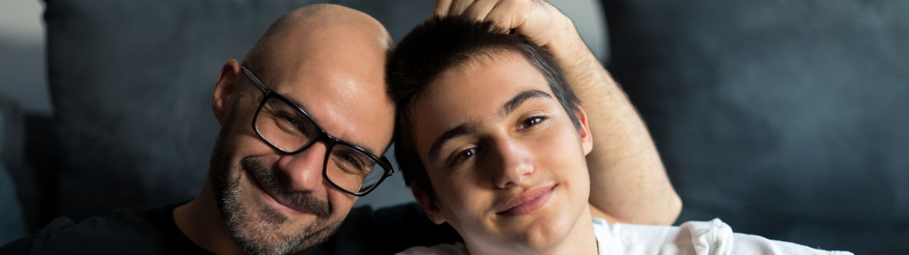 Portrait of father and son bonding in a living room.