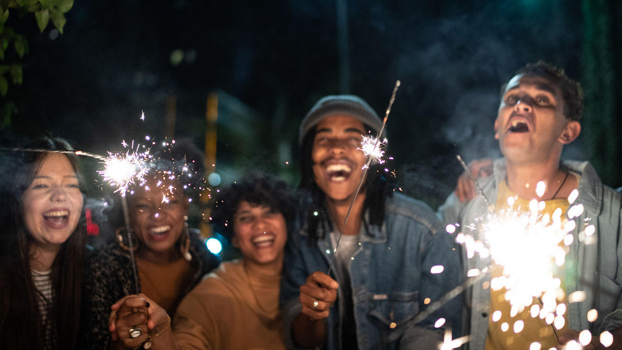 Friends celebrating with sparkers in the street at night