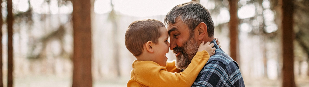 Grand father and grandson embracing in public park