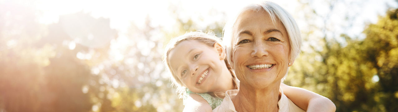 Shot of a little girl and her grandmother enjoying a piggyback ride at the park 