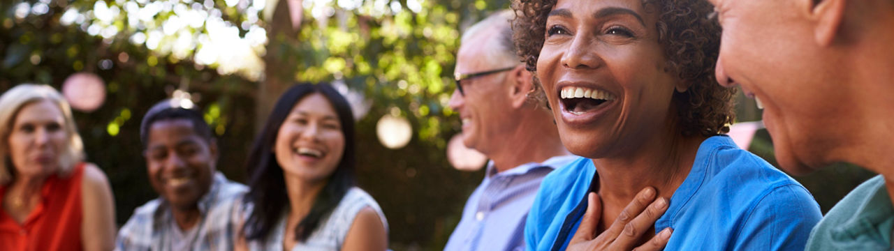 Group Of Mature Friends Socializing In Backyard Together