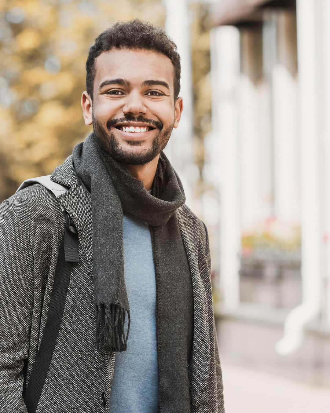 Joyful smiling man in a city. Autumn and winter concept