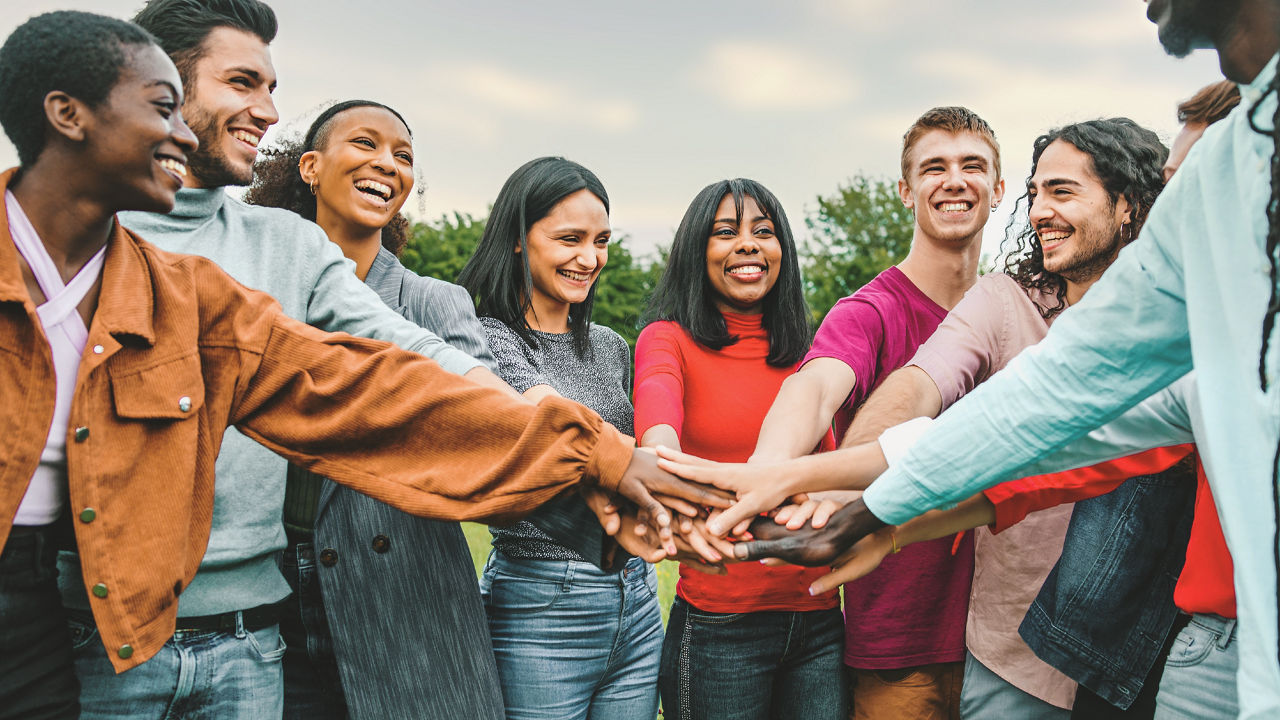 joyful team of multi-ethnic young people friends joining hands together - diversity, unity, trust, oneness, international youth culture concept - interracial person connecting together