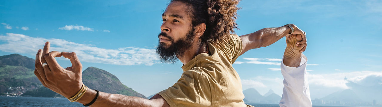 Mid adult man doing yoga on the beach