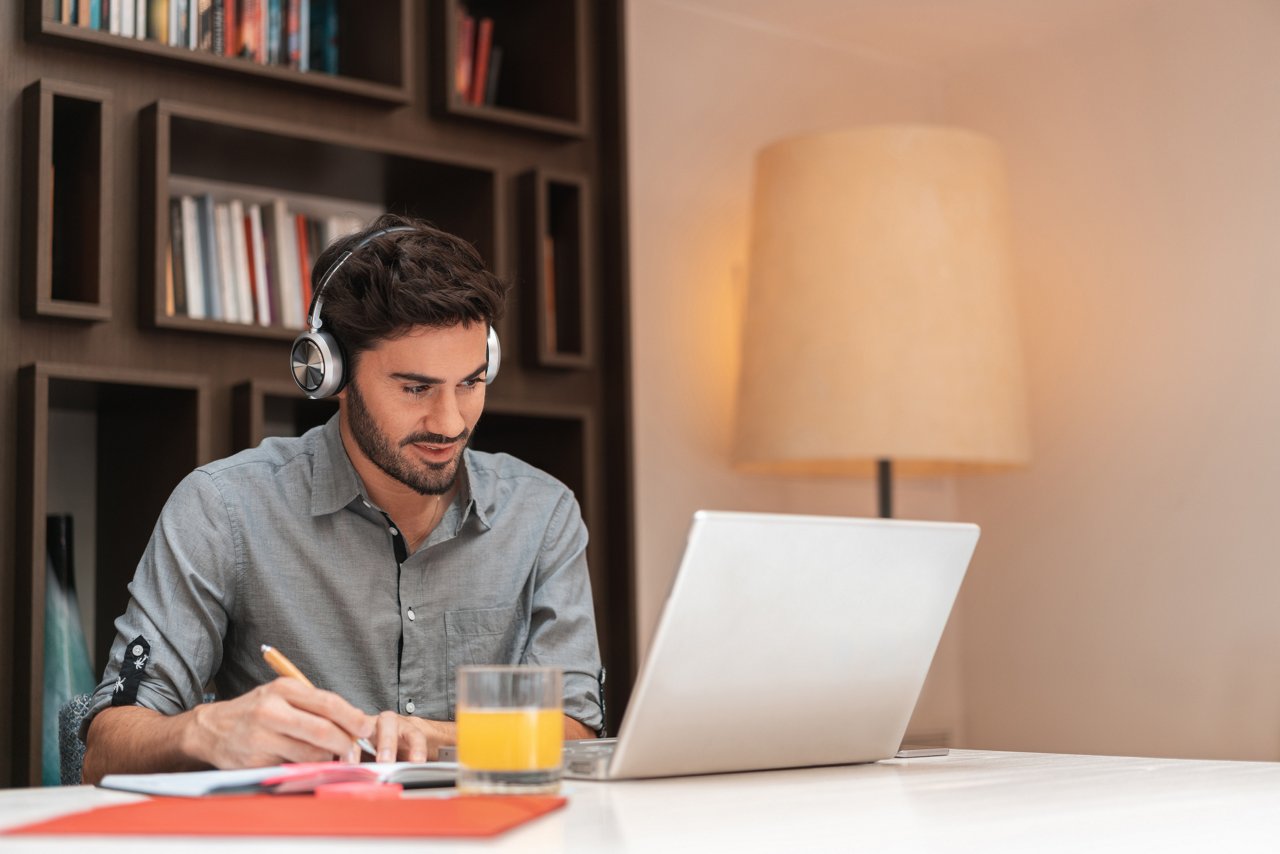 Male with headphones on laptop