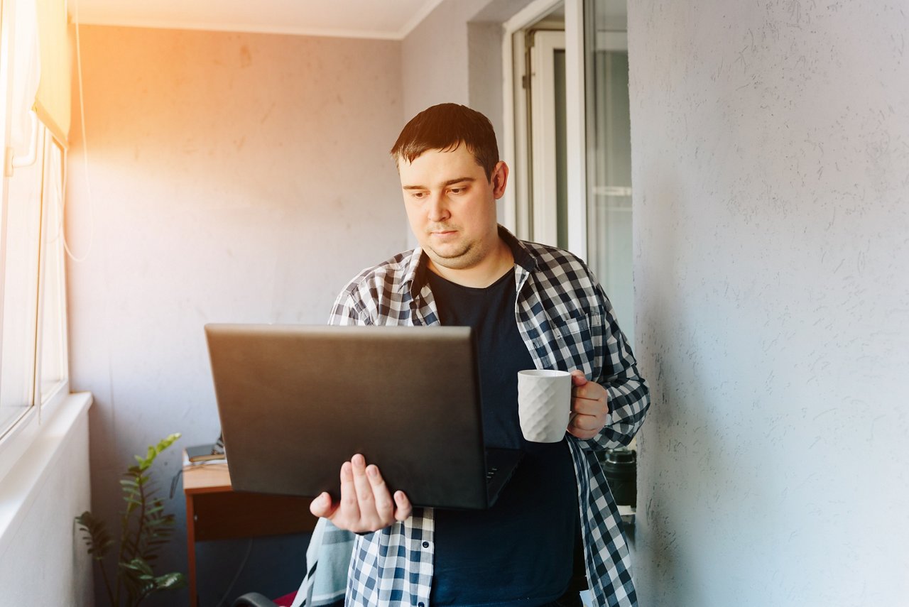 Man with laptop coffee cup in hand