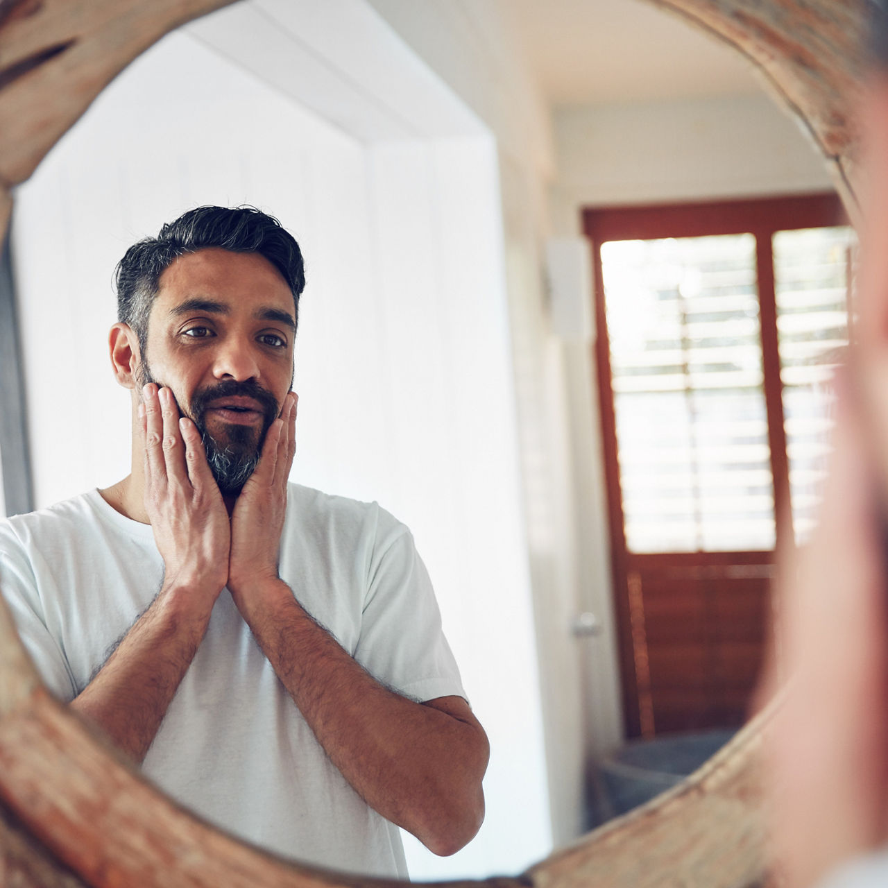 Shot of a mature man looking at his reflection the bathroom mirror