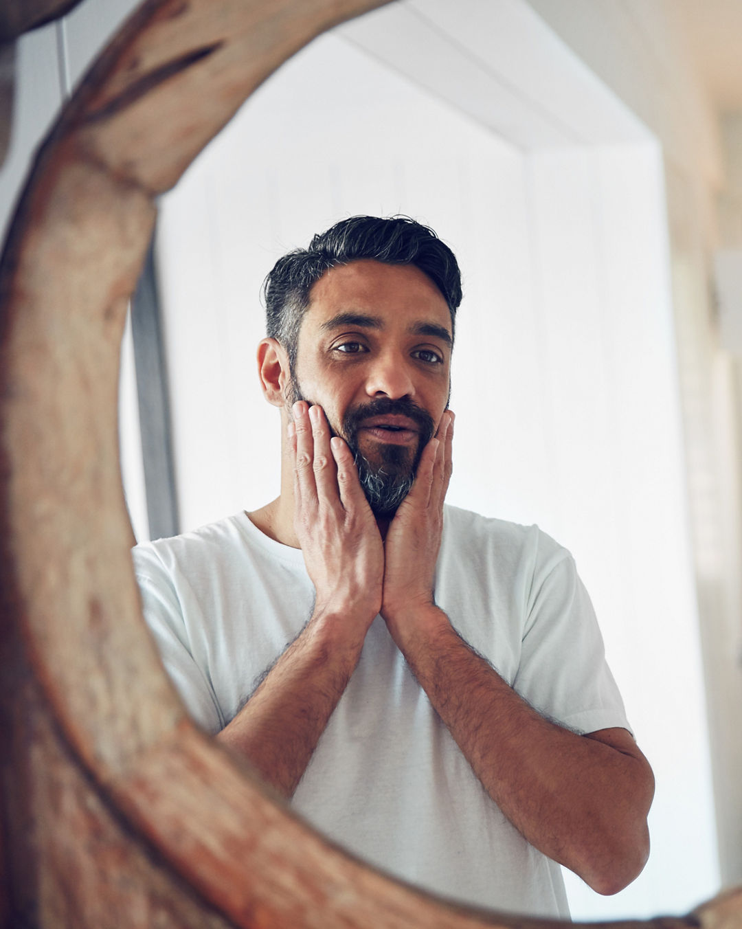 Shot of a mature man looking at his reflection the bathroom mirror