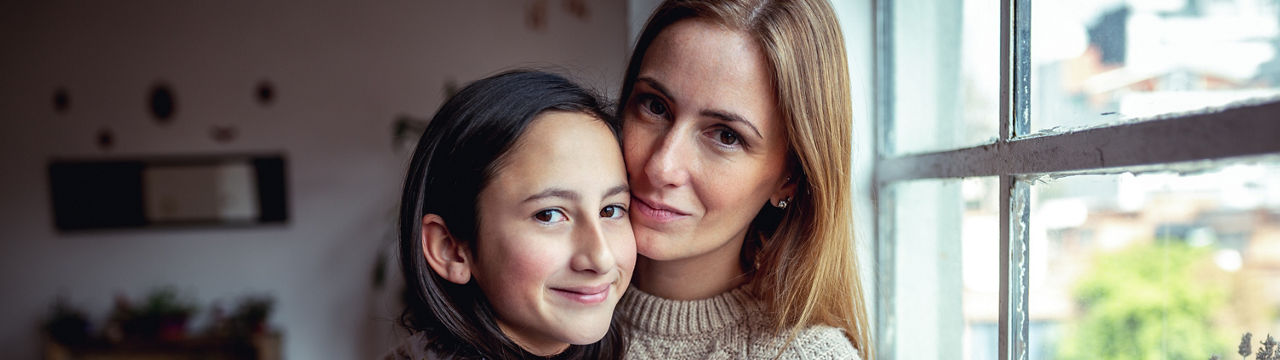 Lovely mother and daughter looking at camera