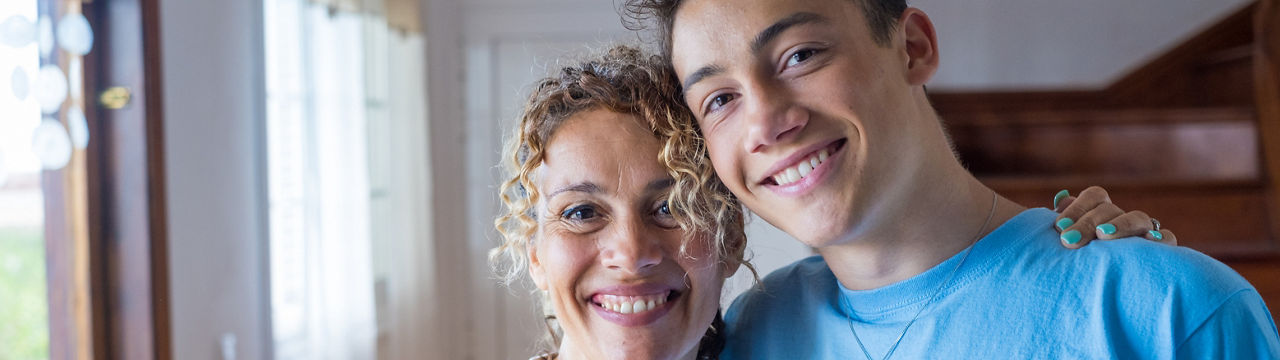 Portrait of grateful teenager man hug smiling middle-aged mother show love and care, thankful happy grown-up son in embrace cheerful mom, enjoy weekend family time at home together, bonding concept