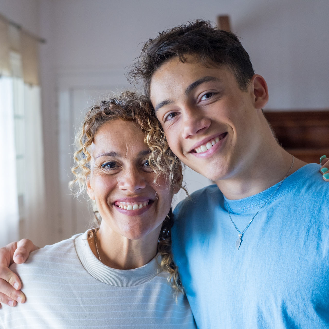 Portrait of grateful teenager man hug smiling middle-aged mother show love and care, thankful happy grown-up son in embrace cheerful mom, enjoy weekend family time at home together, bonding concept