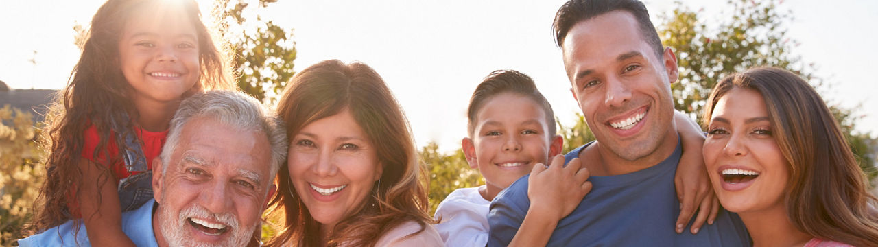 Portrait of multi-generation Hispanic family relaxing In garden at home together