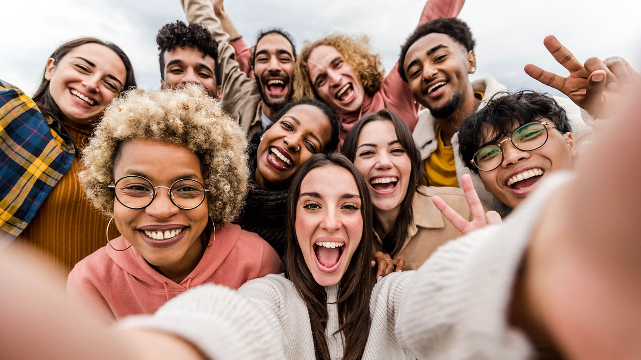 Multiracial friends taking big group selfie shot smiling at camera - Laughing young people standing outdoor and having fun - Cheerful students portrait outside school - Human resources concept