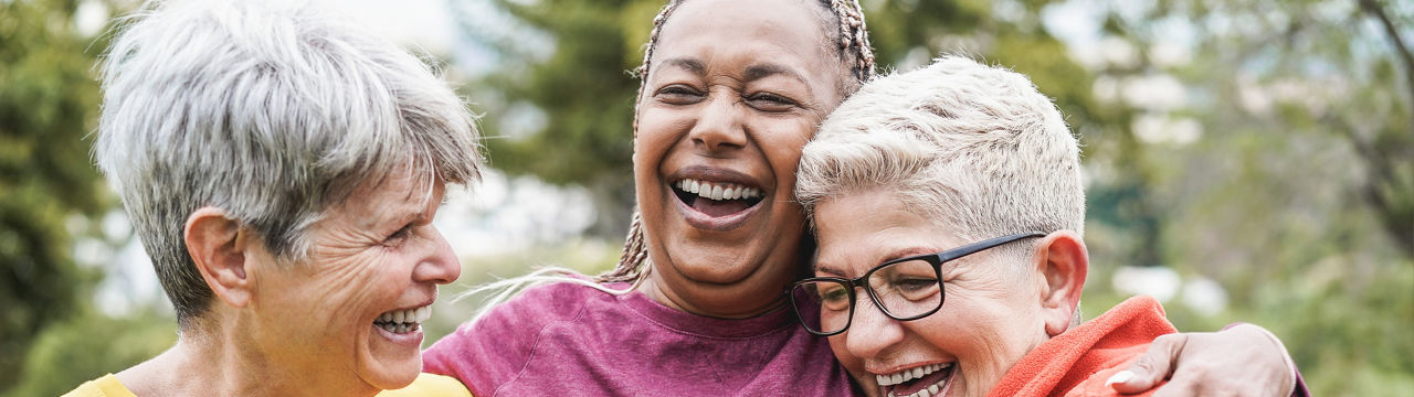 Multiracial senior women having fun together after sport workout outdoor - Main focus on african female face