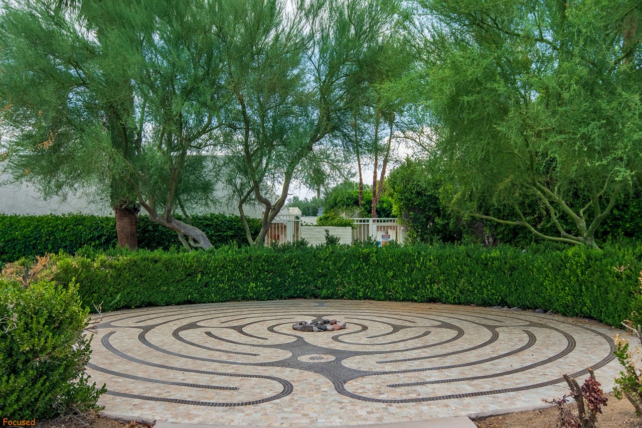 A walking path maze surrounded by green bushes and trees