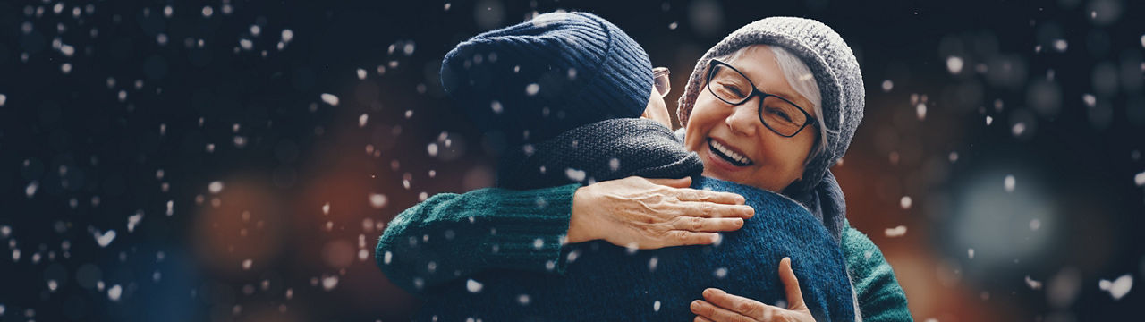 Merry Christmas and Happy Holidays! Portrait of loving family on dark snowy background.