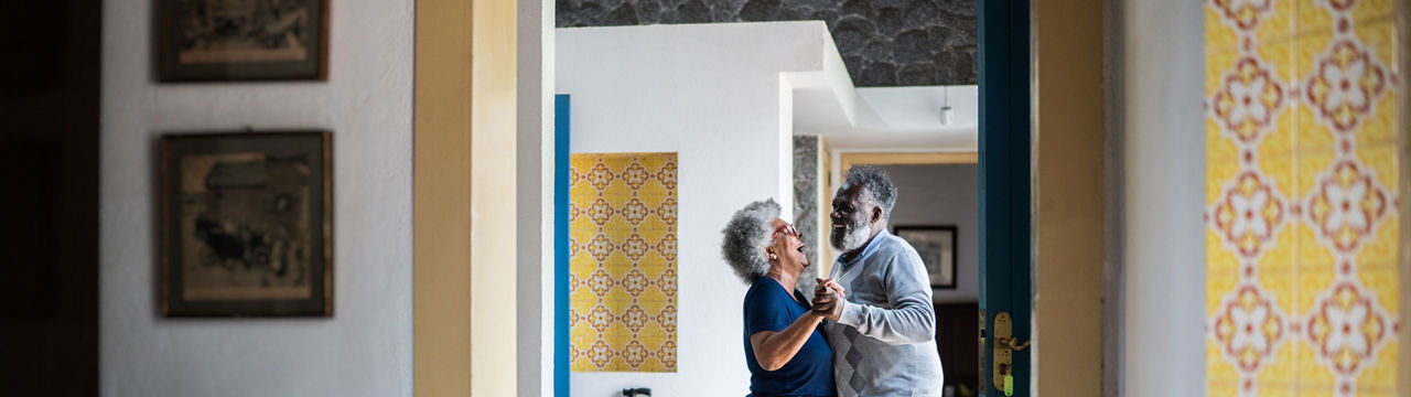 Senior couple dancing at home