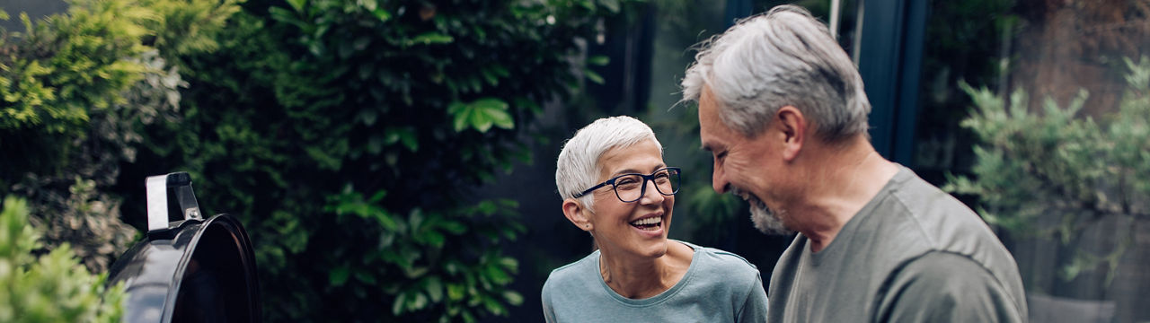 Senior couple preparing barbecue at the backyard